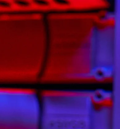 Bild in rot schwarz beleuchtet wie jemand ein Kabel in einen Server steckt