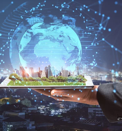 Eine Hand hält ein Tablet mit einer grünen Stadtdarstellung digital darüber ist eine Weltkugel gelegt im Hinterrgund ist eine Skyline