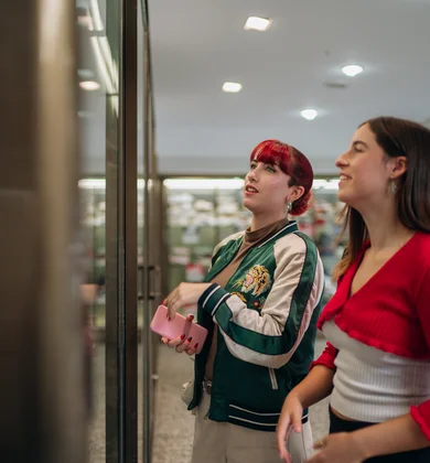Zwei Frauen schauen auf etwas in einem Schaufenster